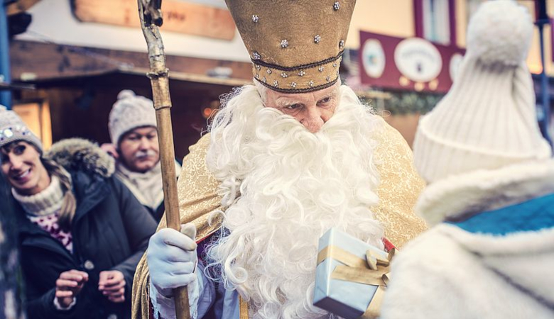 Kinder bekommen vom Nikolaus ein Geschenk.