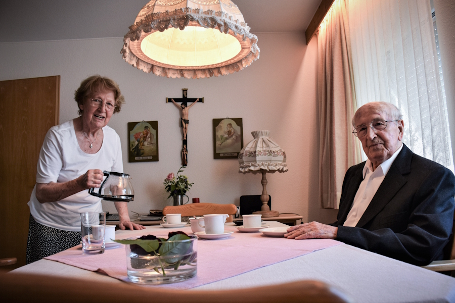 Haushälterin Annemarie Zill und Priester Max Knorr sitzen am Esstisch beim Kaffee in seiner Wohnung in Kempten.