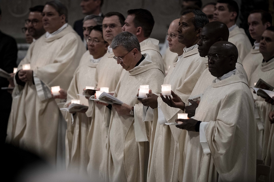 Diakone halten entzündete Kerzen während der Osternacht am 19. April 2025 im Petersdom.