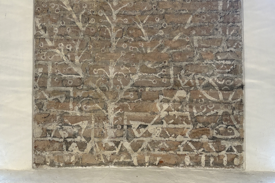 Die Fresken an der Innenwand zeigen zahlreiche Symbole wie Lebensbaum, Sonnenkreis und Dreiecke.