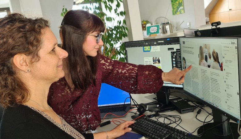 Die Michaelsbund-Grafikerinnen Veronika Jakob und Antonia Griesbeck gestalten ein Layout am PC.
