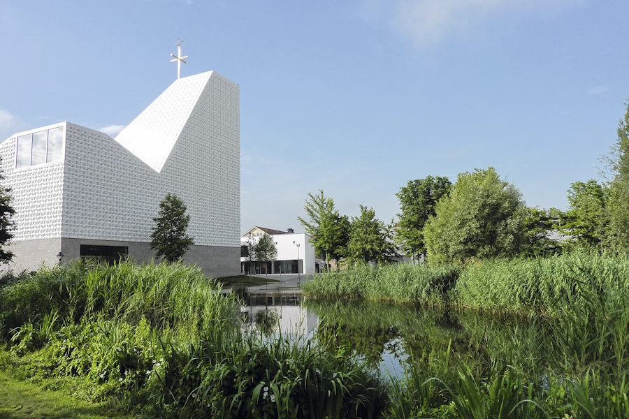 An die gesuchte Kirche grenzt ein Park mit Teich an.