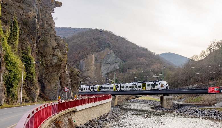 Ein Zug der Ahrtalbahn fährt über eine wiedererrichtete Bahnbrücke.