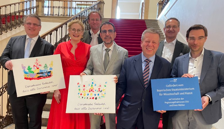 Bei der Übergabe: Claudia Pecher (2. v.l.), Klaus Holetschek (4. v.l.), Stefan Eß (2. v.r.) und Stephan Oetzinger (1. v.r.). Die Kinder-Transparente sind bei Politikerbesuchen in SMB-Büchereien entstanden.