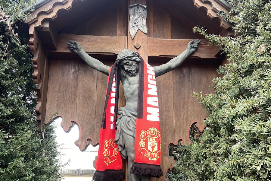 Am Gedenkkreuz an der Münchner Karotschstraße 11 haben Fans von Manchester United einen Schal abgelegt. Es wurde zur Erinnerung an einen Flugzeugabsturz dieser Fußballmannschaft errichtet.