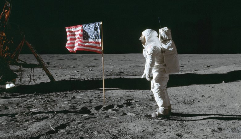 Astronaut Edwin E. Aldrin steht neben der US-Flagge, die 1969 von der Apollo 11 Mission auf dem Mond gehisst wurde.