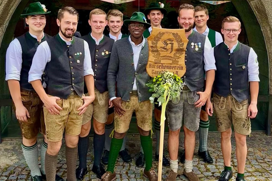 Typisch bayerisch: In Trachtenjanker und Lederhose posiert Pfarradministrator Barthlomew Aondo mit dem Garchinger Burschenverein.