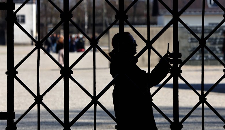 Eine Besucherin steht am Eingangstor zur KZ-Gedenkstätte Dachau.