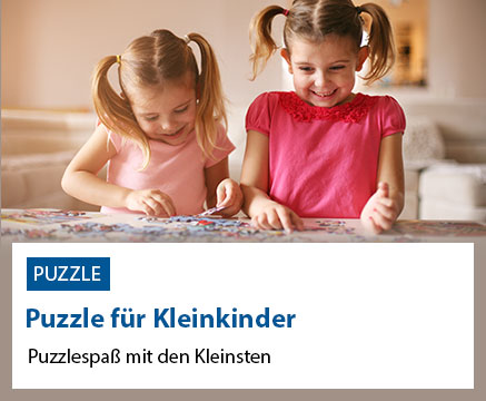 Zwei lächelnde Mädchen mit Zöpfen sitzen an einem Tisch und puzzeln gemeinsam.