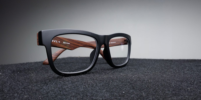 Schwarz gerahmte Brille auf schwarzer Oberfläche
