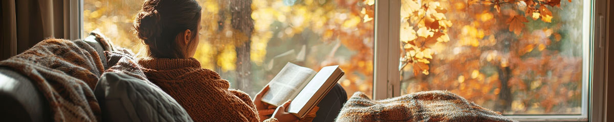 Frau liest ein Buch in einem Zimmer im Herbst