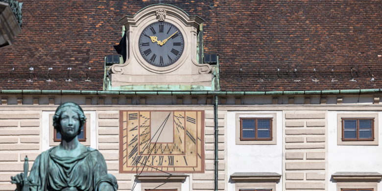 Uhren in der Wiener Hofburg. Während es auf der Zeigeruhr 10.09 Uhr (Sommerzeit) ist, zeigt die Sonnenuhr die „wahre“ Uhrzeit – kurz nach neun – an.