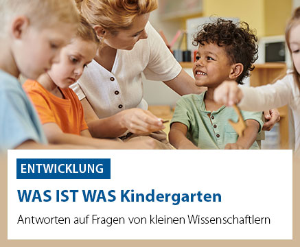 Eine Erzieherin sitzt mit einer Gruppe von Kindern in einem Kindergarten. Ein Kind im Vordergrund trägt ein orangefarbenes T-Shirt, ein anderes ein grünes. Sie lächeln und interagieren miteinander. Text auf dem Bild: 